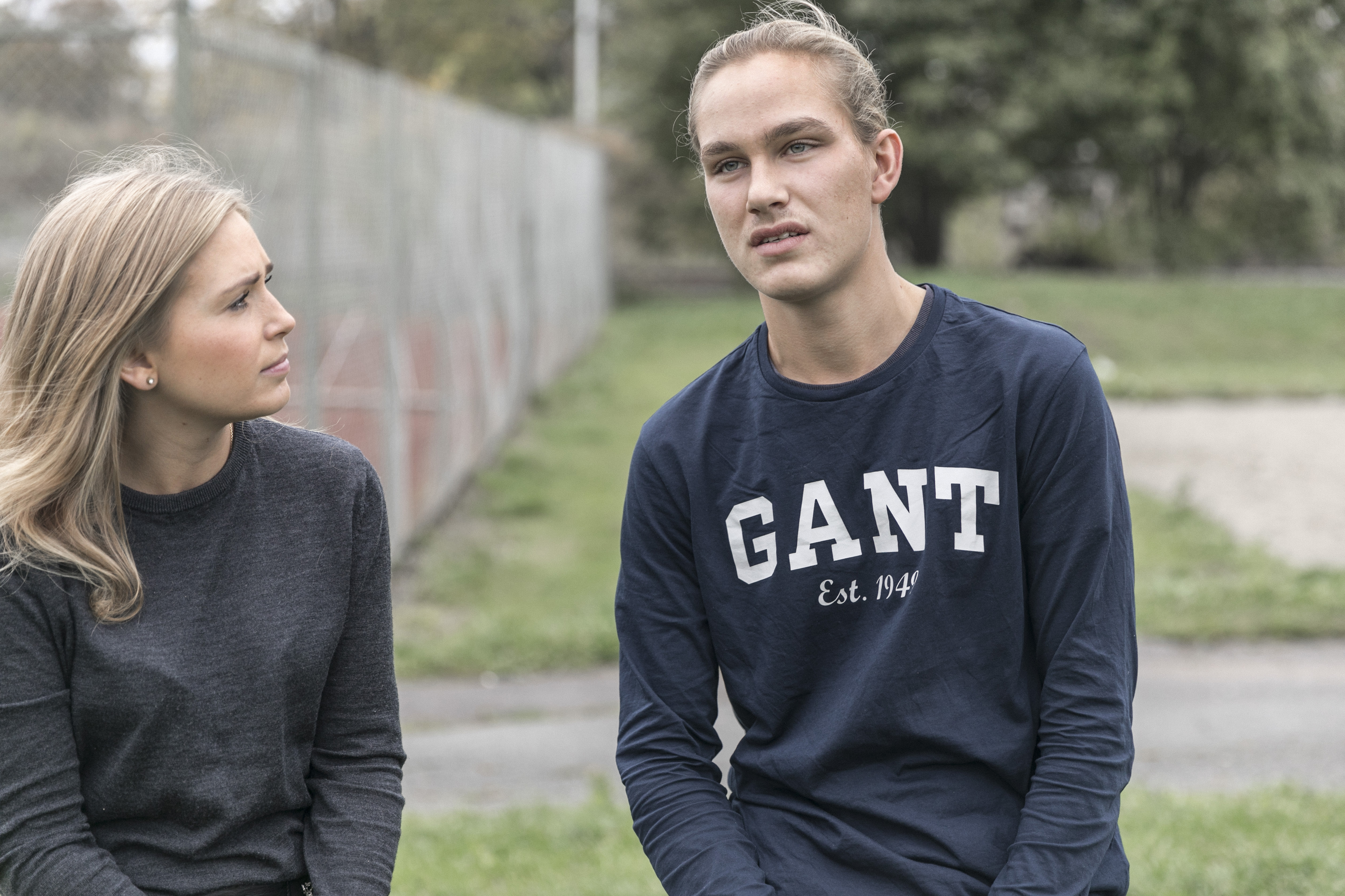 Ung dame ser på tenåringsgutt som stirrer ut i luften