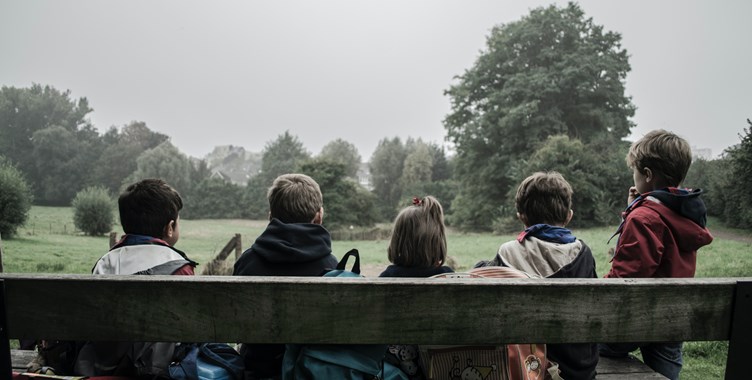 illustrasjonsfoto bakfra av fem barn-pa-benk